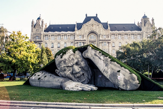 Гигантская скульптура лезет из-под земли на площади Будапешта