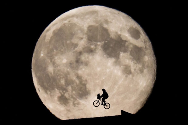 Фото велосипедиста на фоне огромной растущей Луны от Филиппа Шмидли (Philipp Schmidli)