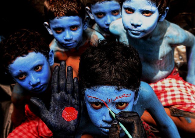 Деревенские мальчишки раскрашиваются для участия в фестивале Кришна-джанмаштами