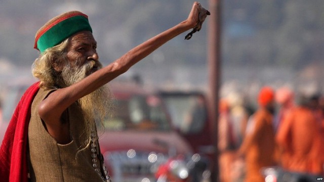 Индийский садху 43 года держит руку поднятой в честь бога Шивы