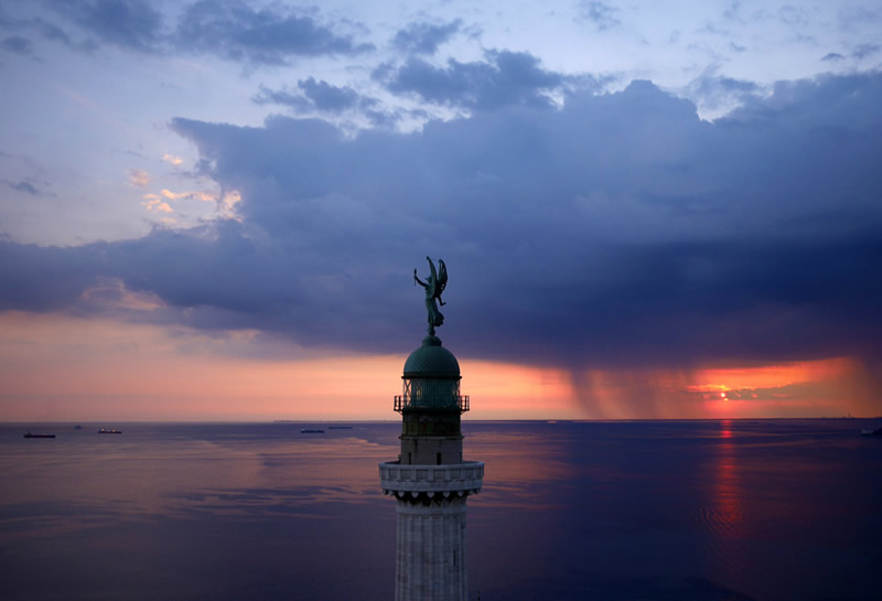 Маяк Фаро делла Виттория (маяк Победы) на закате с видом на залив в городе Триест