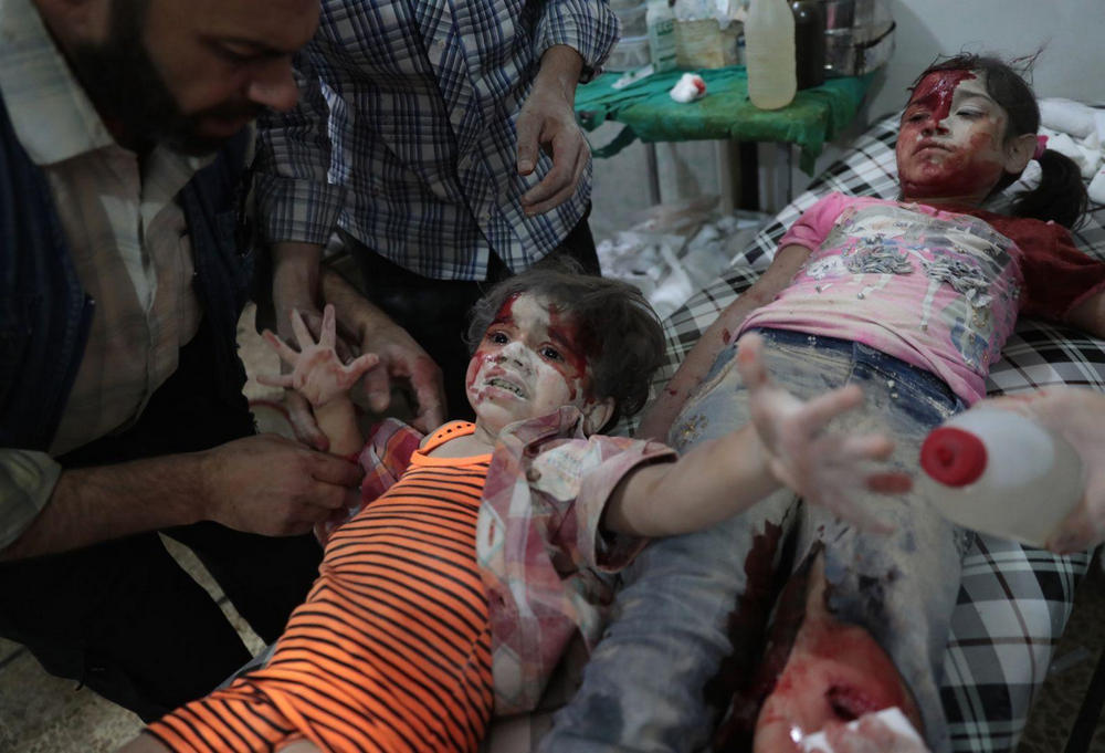 Медики оказывают помощь раненой девочке, Сирия