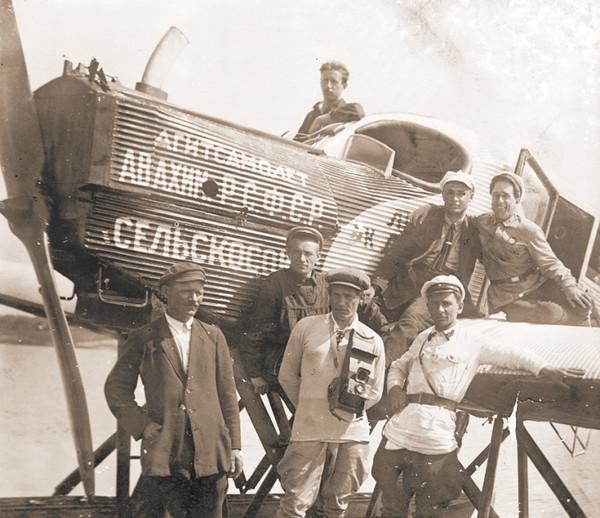 Андрей Платонов (второй слева, прислонившийся к самолету) и Виктор Шкловский (справа, сидит на крыле аэроплана)